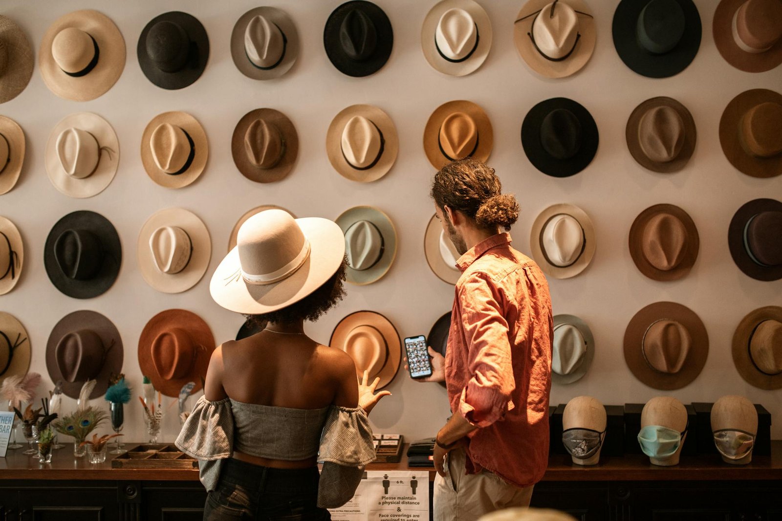 A stylish couple exploring a hat boutique, showcasing diverse headwear.